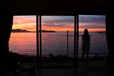 Silhouette of people in sea at sunset