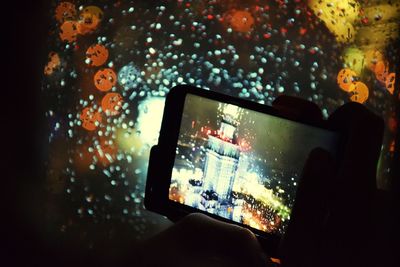 Man photographing through smart phone in rain