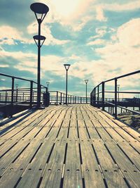 Surface level of pier on street against sky