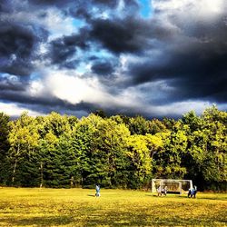 Scenic view of grassy field against cloudy sky