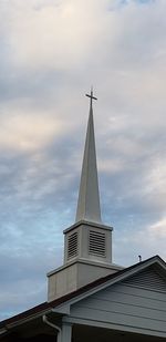 Low angle view of cross on building against sky