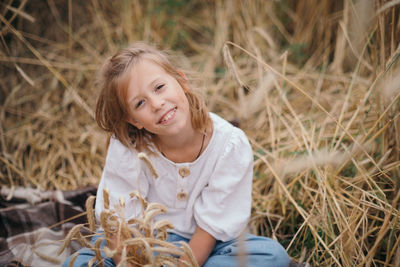 Portrait of young woman standing amidst plants on field