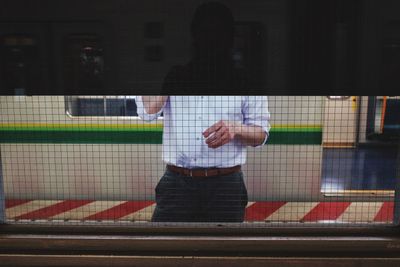 Reflection of man playing on glass window