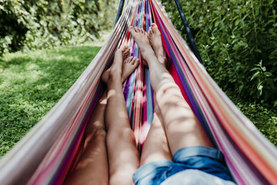 Girls lying in hammock on sunny day