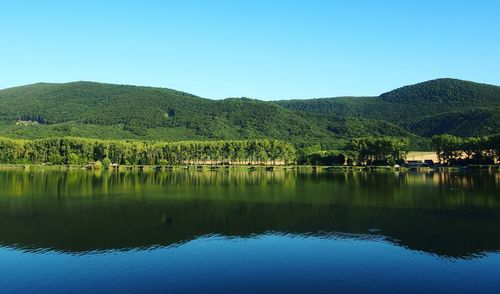 Scenic view of lake against clear blue sky