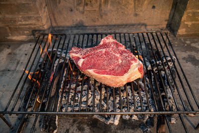 Italian roasted steak on a barbecue grill. appetizing piece of meat cooking on fire on bbq 