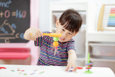 Cute girl holding toy at home