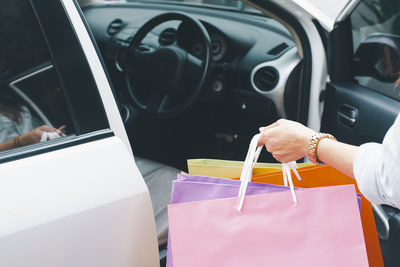 Midsection of woman holding gift to car