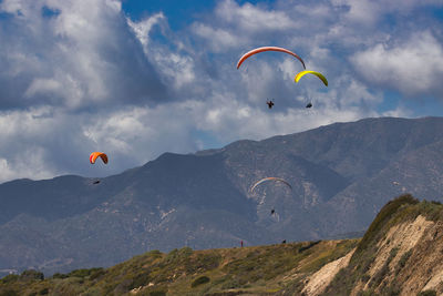 Low angle view of person paragliding against mountain