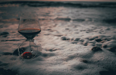Wine glass on sand at beach