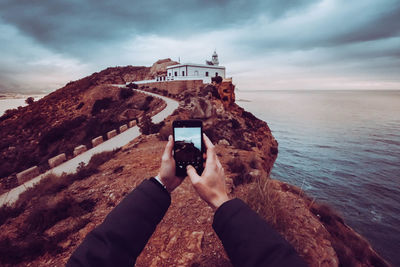 Low angle view of camera photographing against sky