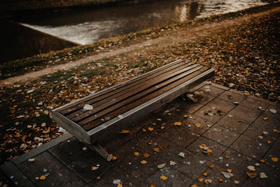 High angle view of empty bench by railroad tracks