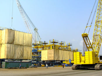 Vehicles on pier against clear sky