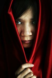 Close-up portrait of young woman covering head with scarf