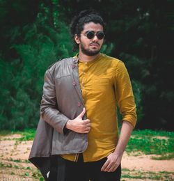 Young man standing against plants