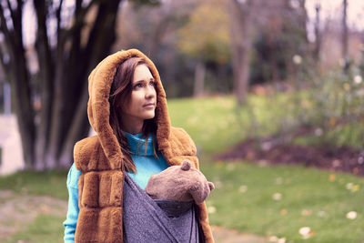 Portrait of woman standing against tree