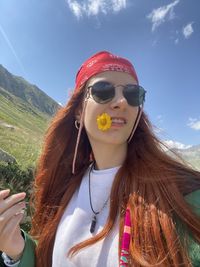 Portrait of young woman wearing sunglasses against sky