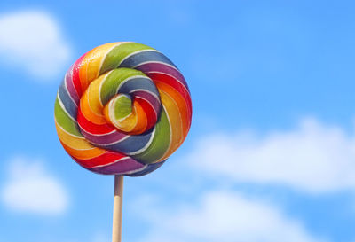 Low angle view of multi colored umbrella against blue sky