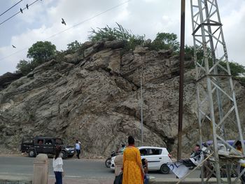 People on rocks against sky