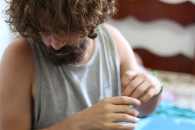 Midsection of man looking away while sitting on floor