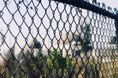 Close-up of chainlink fence against sky