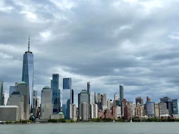 Modern buildings in city against cloudy sky