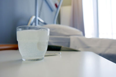 Pill in water glass on table in hospital