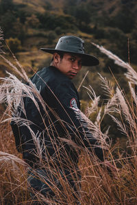 Young man looking away on field