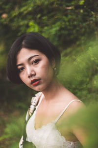 Portrait of sensuous young woman against trees