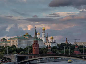 Spasskaya tower by moscva river against cloudy sky