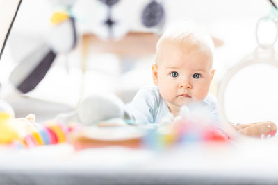 Portrait of cute baby boy lying on bed