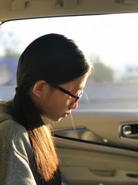 Side view of young woman in car