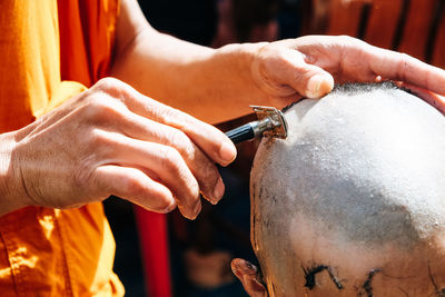 Close-up of man shaving head of boy