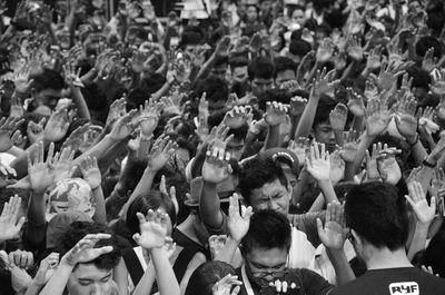 Crowd with arms raised standing outdoors