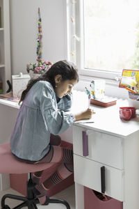 Girl studying at desk in house