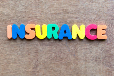 High angle view of colorful insurance text on wooden table