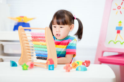 Young girl learn counting by using abacus for homeschooling