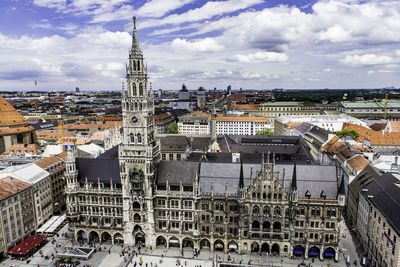 High angle view of munich cathedral amidst buildings against cloudy sky in city