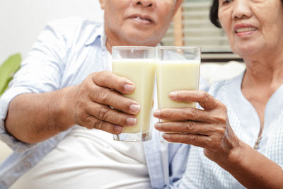 Midsection of couple holding drink