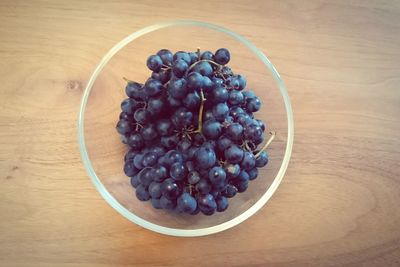 High angle view of grapes in bowl on table