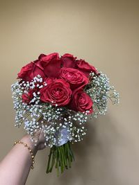 Close-up of hand holding rose bouquet