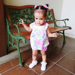 Cute girl standing on tiled floor