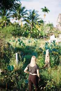 Rear view of woman walking on field