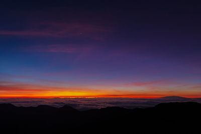 Scenic view of silhouette mountains against sky during sunset