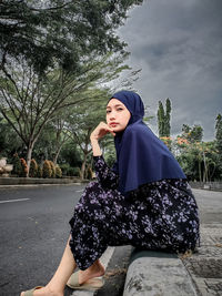 Portrait of young woman sitting outdoors