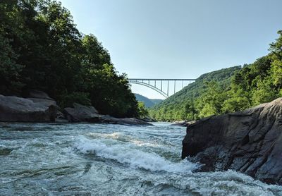 Arch bridge over river against sky