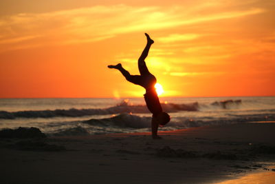 Full length of silhouette woman on beach against sky during sunset