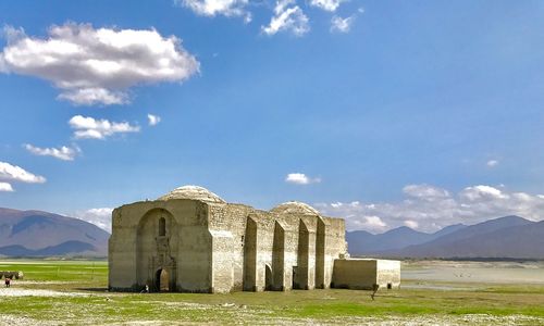 Built structure on field against sky