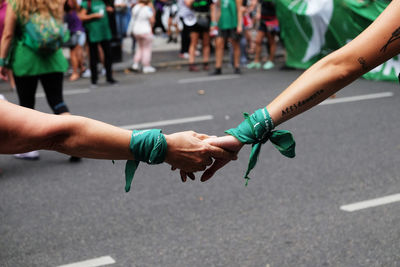 Close-up of woman holding hands on road