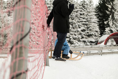 Man standing on snow covered tree